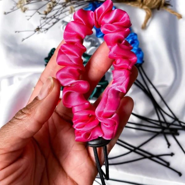 etalhe do Scrunchie Afropuff rosa em cetim na mão