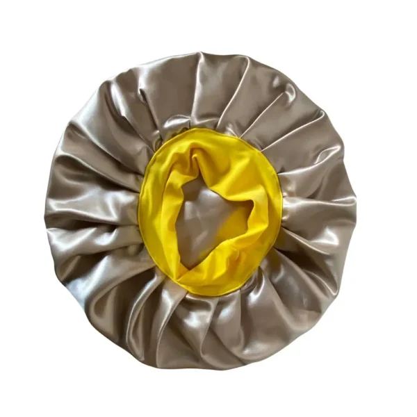 Vista superior da touca de cetim dourada com forro amarelo, ideal para proteger o cabelo durante o sono.